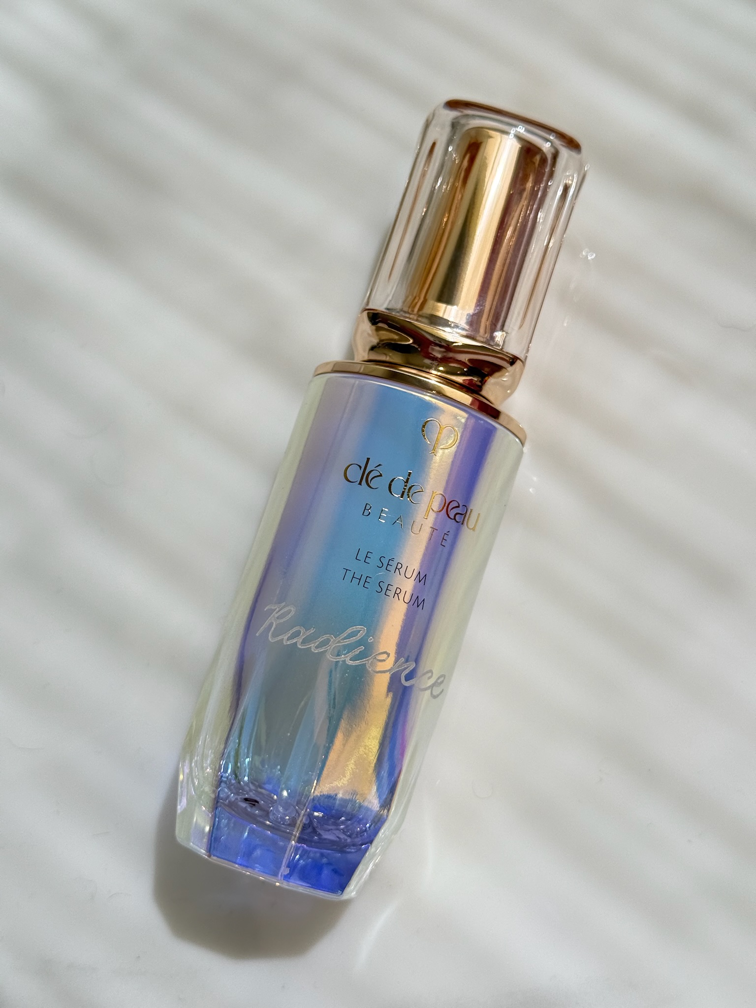 Clé de Peau Beauté Le Sérum iridescent glass bottle with calligraphed script