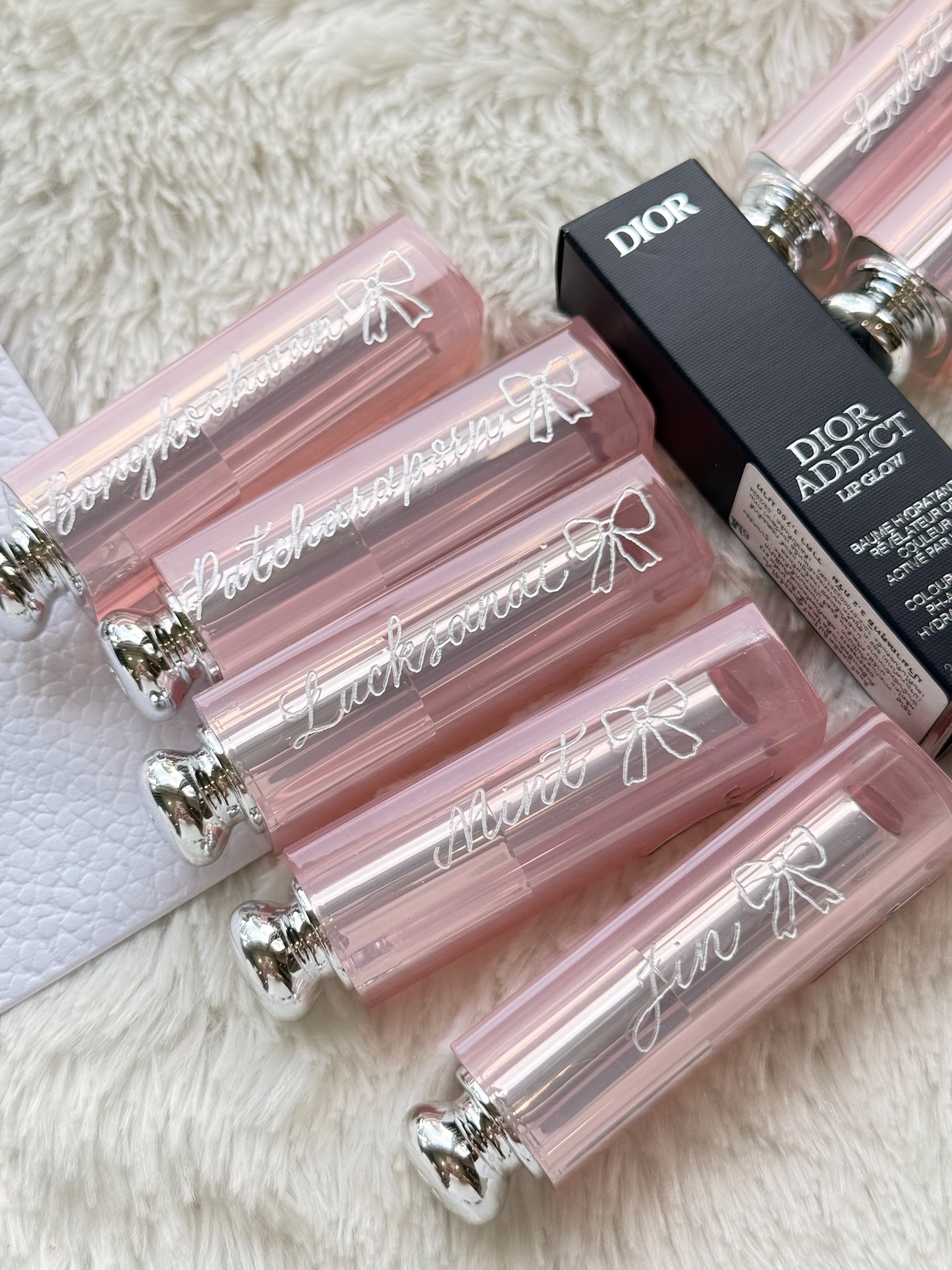 Dior Addict lip glosses with calligraphy on pink packaging