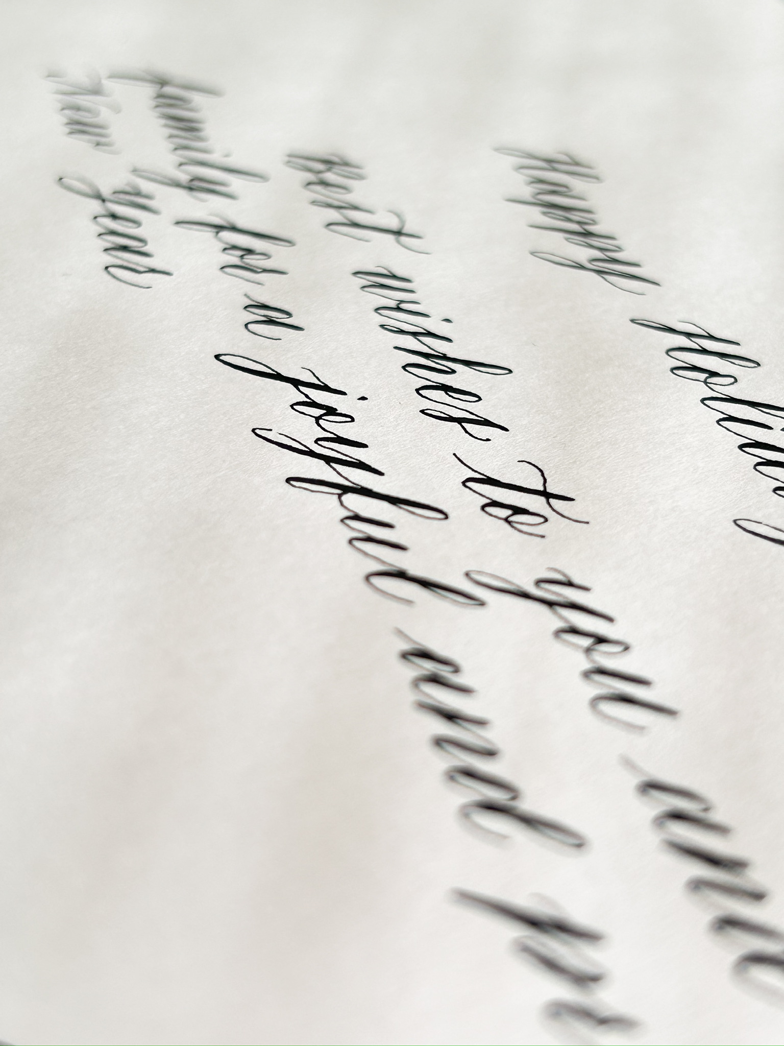 Close detail of calligraphy lettering on Jaeger-LeCoultre Holiday Season card, ink on white paper